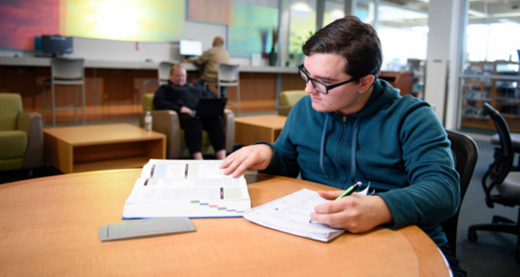 Student studying in common area by himself