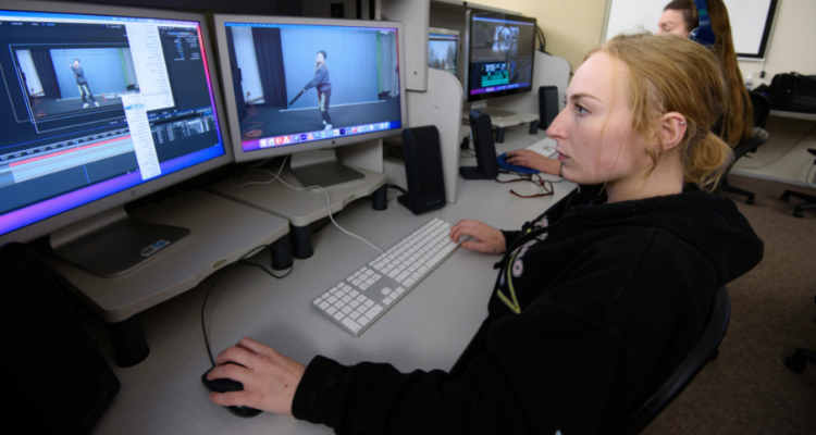 two female students in computer lab editing video footage