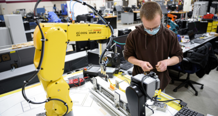 student working with robotic arm in lab
