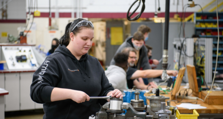 students testing industrial machine with instructor supervising