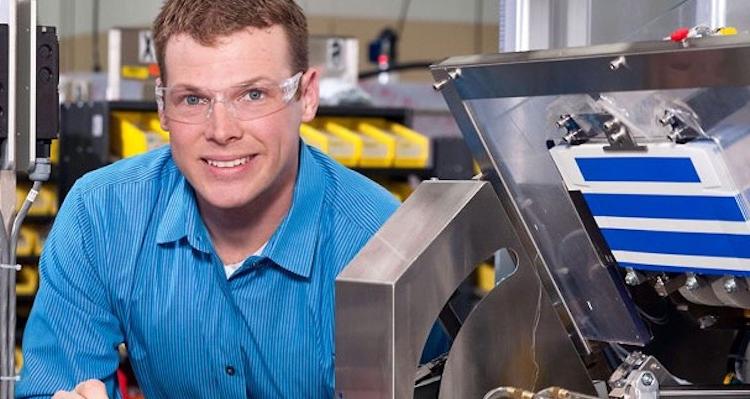 male student setting up machine for production