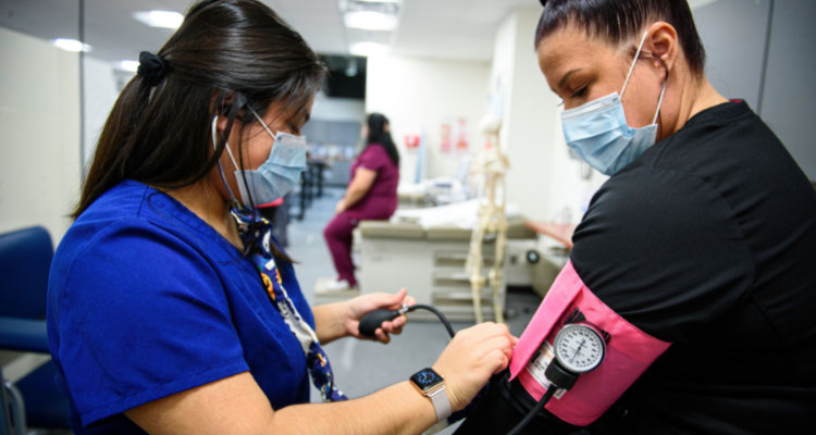 female healthcare working taking patient blood pressure in a clinic