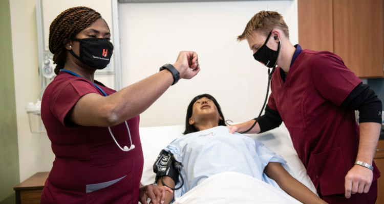female and male nursing students evaluating health of dummy patient
