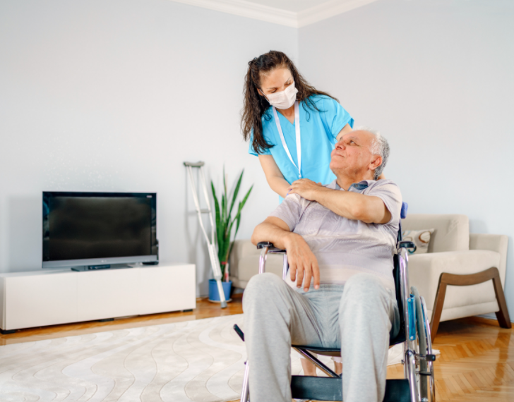 female healthcare worker assisting elderly patient in wheelchair