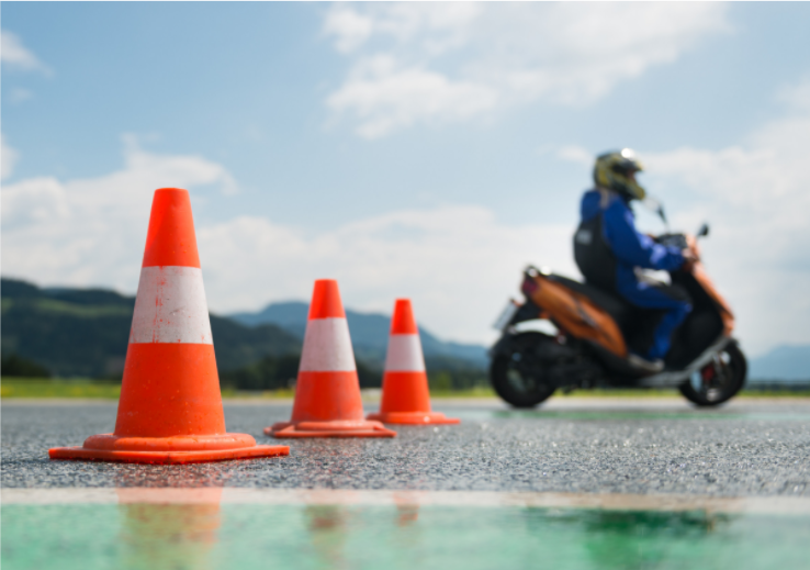 person on moped with orange traffic cones