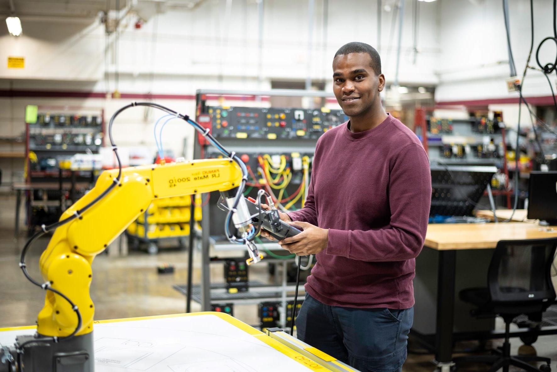 Robotics student with robot arm