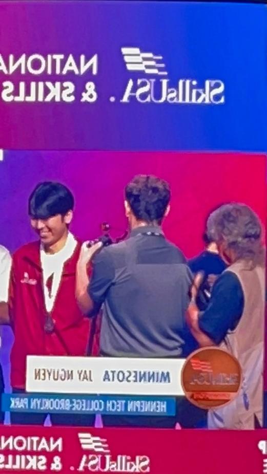 Student, Jay Nguyen, accepts medal