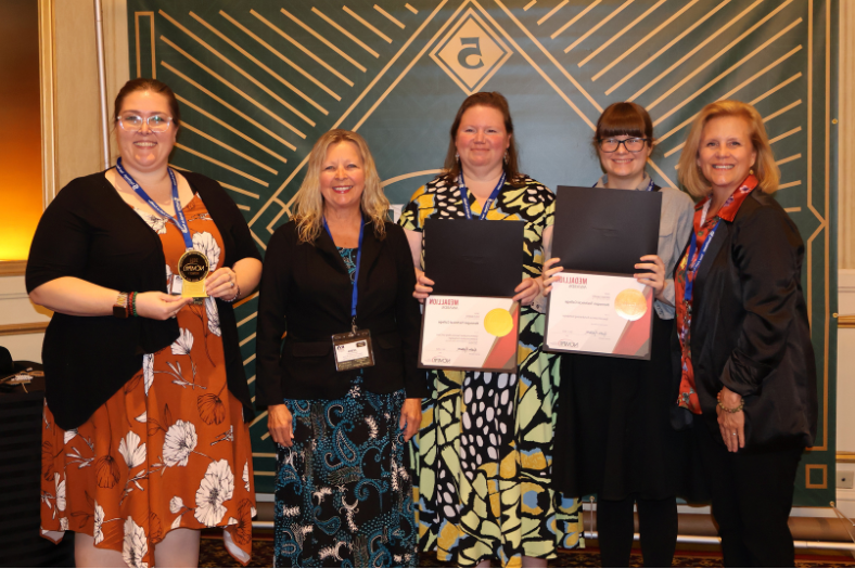 MarCom staff gathered in a row with their NCMPR awards